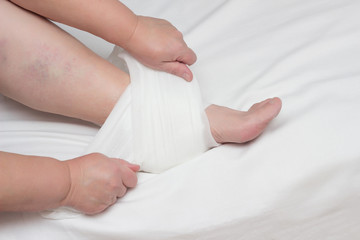 Fototapeta na wymiar A woman sets up a warming and anti-inflammatory compress on the heel with heel spurs, plantar fasciitis, close-up