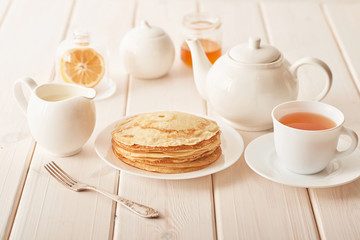 Healthy summer breakfast, homemade classic american pancakes with honey,cozy morning, copy space. Pancakes, teapot, honey on white wooden table. Pancake week. russian traditional holiday Maslenitsa