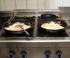 Cook preparing fried pieces of meat in a frying pan in a restaurant, close-up, fillet