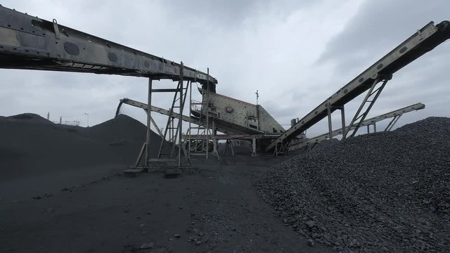 A special coal distributing machine is dropping chunks of coal into the big pile