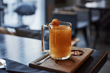 Close up photo of the finished order. Yellow drink on the special stand with one cookie in the hole