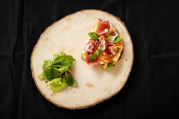 Sandwich with jamon and lettuce on a wooden tray