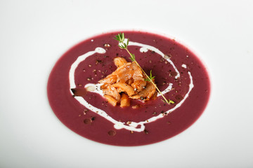 Close up of red cream soup with squid dish