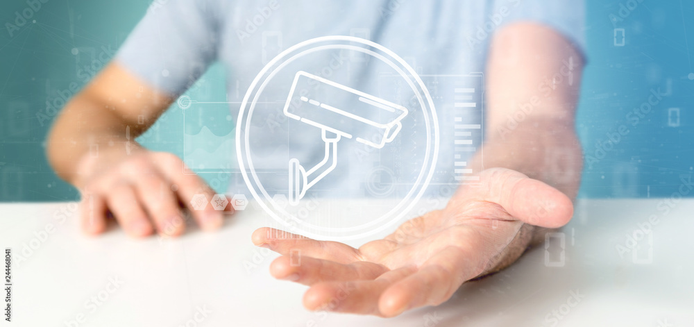 Poster businessman holding security camera system icon and statistics data - 3d rendering