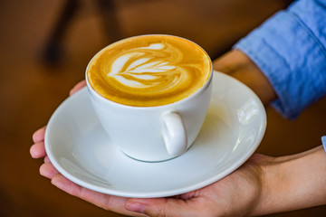 Hands holding coffee cup flower on coffee cup and woman finger.