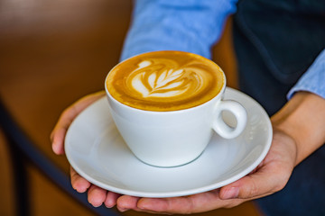 Hands holding coffee cup flower on coffee cup and woman finger.