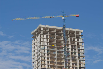 Tower crane against the building under construction. Construction of a new district