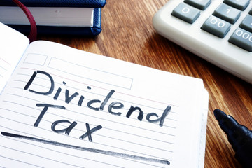 Dividend tax concept. Note pad and calculator.