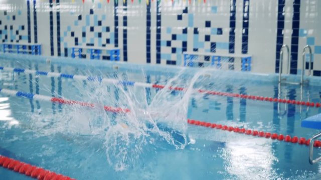 Disabled swimmer jumping into a pool, close up.