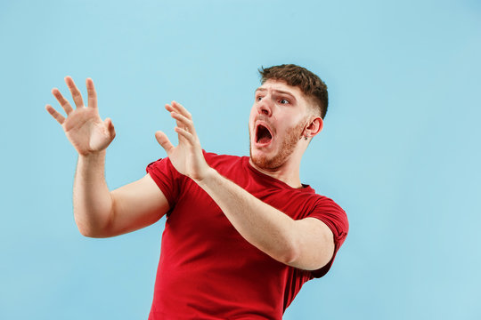 I'm afraid. Fright. Portrait of the scared man. Business man standing isolated on trendy blue studio background. male half-length portrait. Human emotions, facial expression concept