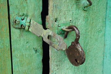 old bolt and opened lock on wooden doors