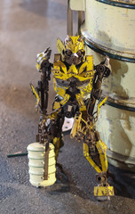 Obraz premium Yellow robot is carrying a lunch box. Hungry robot at Chiangmai walking street, Thailand 