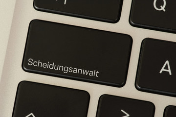 Ein Computer und eine Taste mit dem Aufdruck Scheidungsanwalt