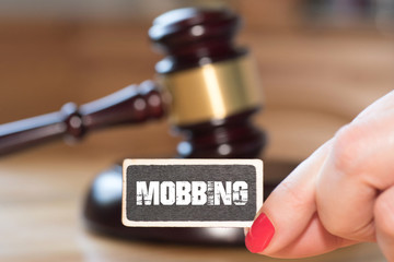 Ein Richterhammer, eine Frau und Mobbing