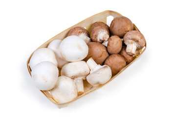 Cultivated raw white and brown mushrooms in the wooden basket
