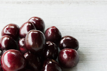red sweet cherry on a light wooden background 