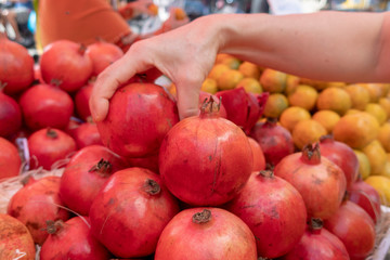 Pomegranates for sale in the market.The pomegranate is a fruit-bearing deciduous shrub or small tree in the family Lythraceae that grows between 5 and 10 m tall. The fruit is typically in season in th
