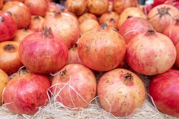 Pomegranates for sale in the market.The pomegranate is a fruit-bearing deciduous shrub or small tree in the family Lythraceae that grows between 5 and 10 m tall. The fruit is typically in season in th