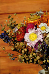 Bouquet of dried colorful flowers in front of a wooden background