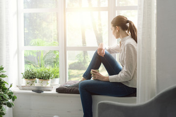 Woman relaxing at home and having coffee