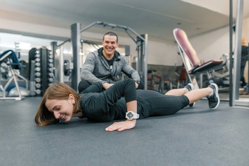 Fototapeta na wymiar Young woman doing exercises with personal instructor in gym. Sport, athlete, training, healthy lifestyle and people concept