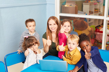 Lehrerin und Kinder mit Daumen hoch