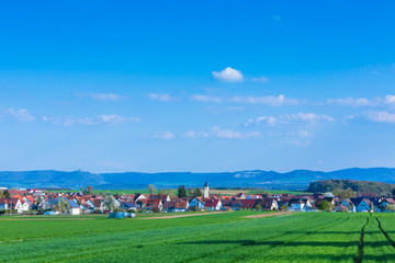 Fototapeta na wymiar Idyllisches Dorf Wolfschlugen mit der schwäbischen Alb im Hintergrund