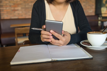 Young Asian lady using smartphone at the cafe