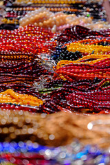 colored rosaries, strings of colored prayer beads, Multicolored beads from seeds on the market, colorful background