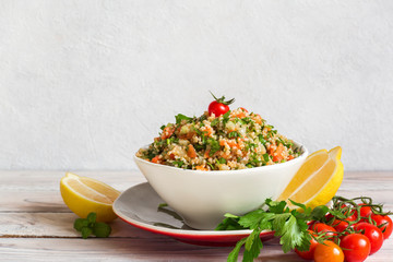 Tabbouleh -  is a Levantine vegetarian salad made  of  chopped parsley, with tomatoes, mint, onion and bulgur, and seasoned with olive oil, lemon juice.
