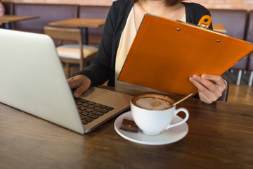 Young businesswoman reading the finance report, working on laptop