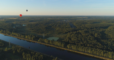 Aerial view Hot air balloons in sky over fields in countryside, beautiful sky and sunset. Aerostat fly over countryside.