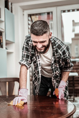 Cheerful positive man standing near the table