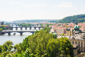Scenic view of bridges on the Vltava river and of the historical center of Prague: buildings and landmarks of old town with red rooftops