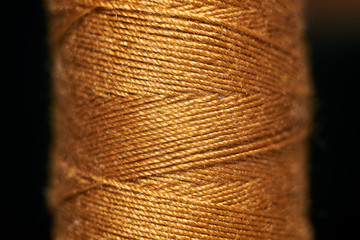 a hank of orange thread in the enlarged form on a black background. Macro shooting