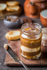 Homemade salted caramel sauce with cookies in jar on rustic background.