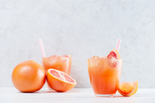 Two glasses of fresh grapefruit juice on the white table