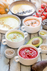 Variety of different colorful vegetable cream soups in a bowls. Concept of healthy eating or vegetarian food.