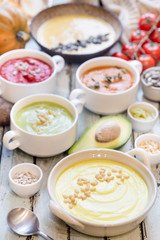 Variety of different colorful vegetable cream soups in a bowls. Concept of healthy eating or vegetarian food.