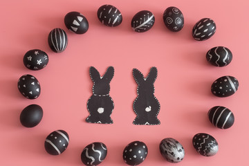 Easter composition with eggs and the Easter Bunny on a pink background