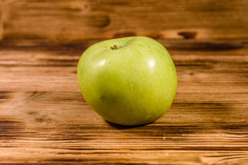 Ripe green apple on a wooden table