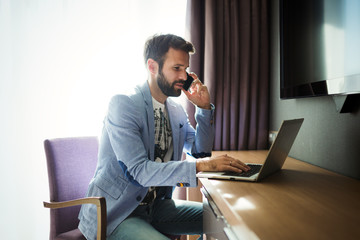 Businessman working on computer in hotel room