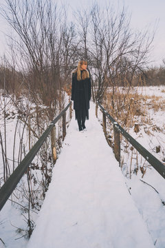 Lonely woman walking in park in winter. 