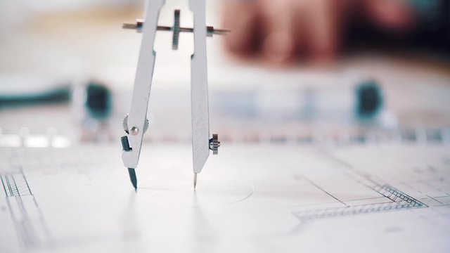 The architect draws a project of an apartment house using a compass. Close view and very smooth dolly shot 4K video