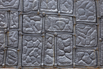 backgrounds, textures, metal wall is decorated with forged elements. Strong wrought iron door with ornament. Strong wrought iron door with ornament 