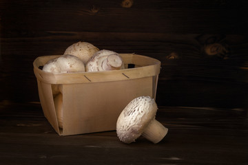 Fresh organic champignons on wooden background