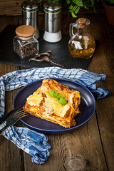 Piece of tasty hot lasagna with red wine.
