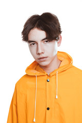 portrait of a teen guy in a yellow raincoat brunette in the studio