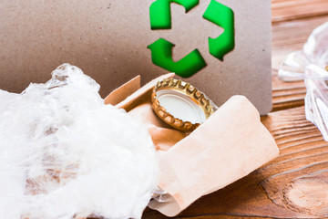 Environmental protection, ecology and recycling concept, recycle sign, notepad and garbage on dark wooden background