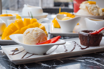 Chocolate lava cake with ice cream on white plate.